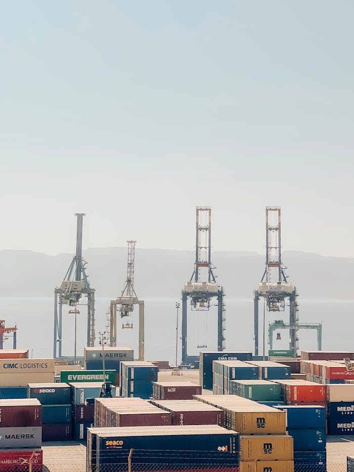 Cranes and shipping containers at Aqaba Port, Jordan, on a clear day.