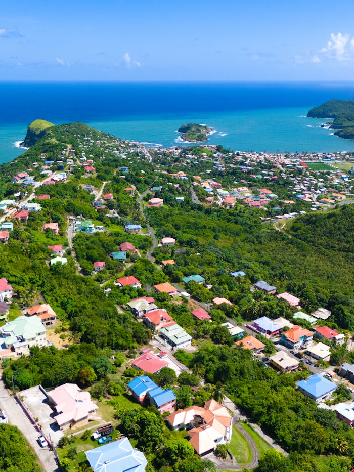 Stunning aerial shot of a lush coastal town in Saint Lucia, showcasing vibrant homes and turquoise waters.